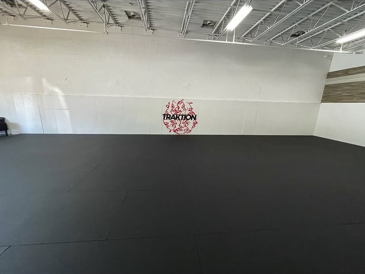 Traktion Jiu Jitsu Academy training room with the academy logo on the wall